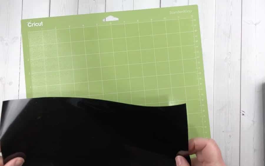 Black vinyl on a green Cricut cutting mat.