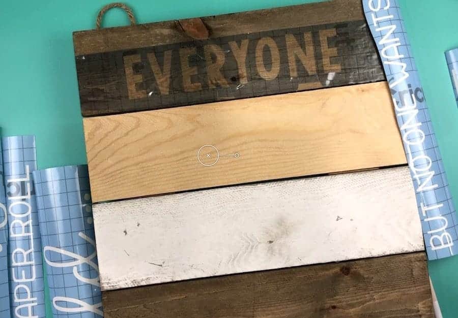 Wooden sign with stencil vinyl cut into strips.